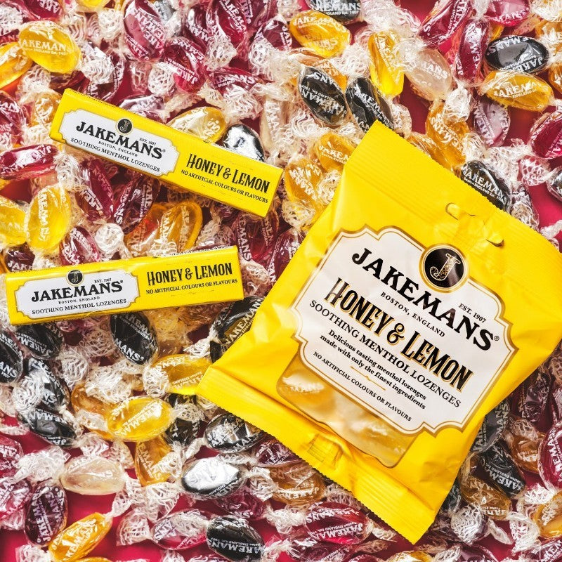 Jakemans Honey & Lemon Menthol Lozenges bag packaging honey lemon flavour 12 x 73g serving suggestion image