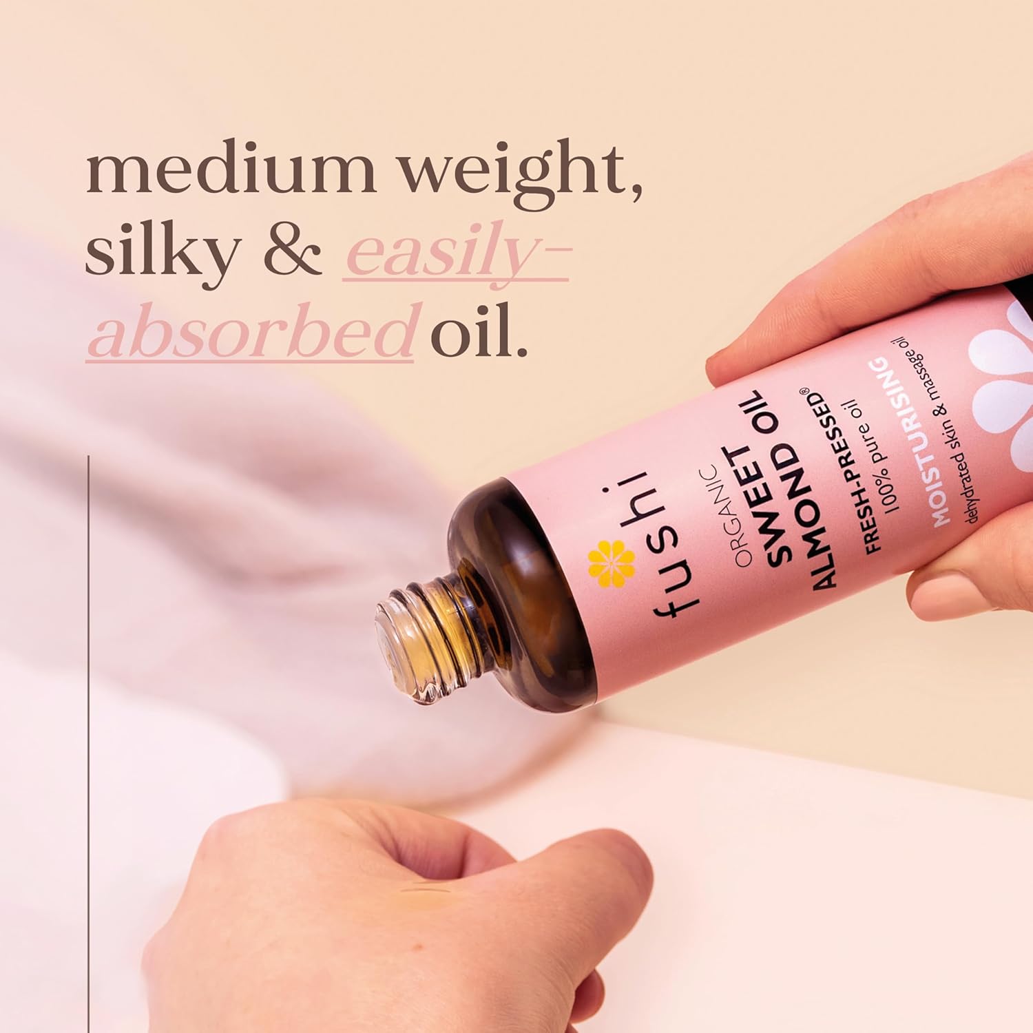 Person pouring Fushi Sweet Almond Oil into another container with text describing the oil's properties.