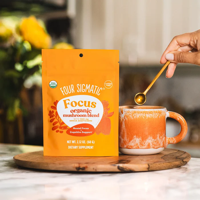 How to Use: Scoop of Four Sigmatic Mushroom Blend powder next to a glass of liquid.